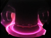 ASDEX Upgrade, the tokamak at the Max Planck Institute for Plasma Physics, Garching, Germany. The violet light is emitted by the plasma. © MPI für Plasmaphysik